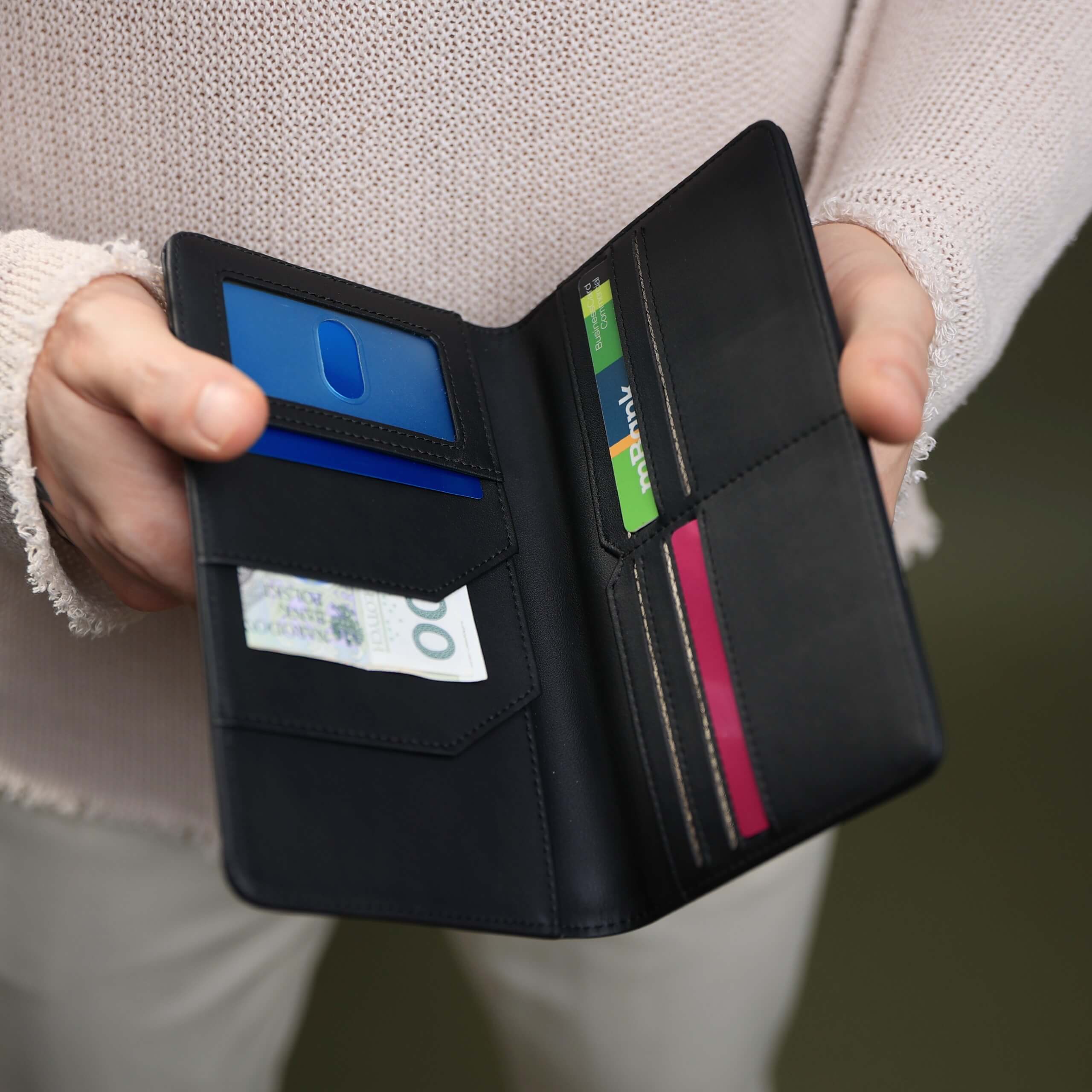 Otwarty czarny portfel podróżny z przegródkami na karty, dokumenty i banknoty
