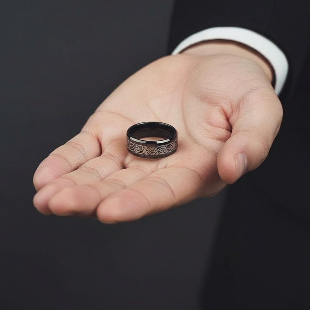 Otwarta dłoń mężczyzny w garniturze z czarno-srebrnym stalowym pierścieniem z celtyckim motywem